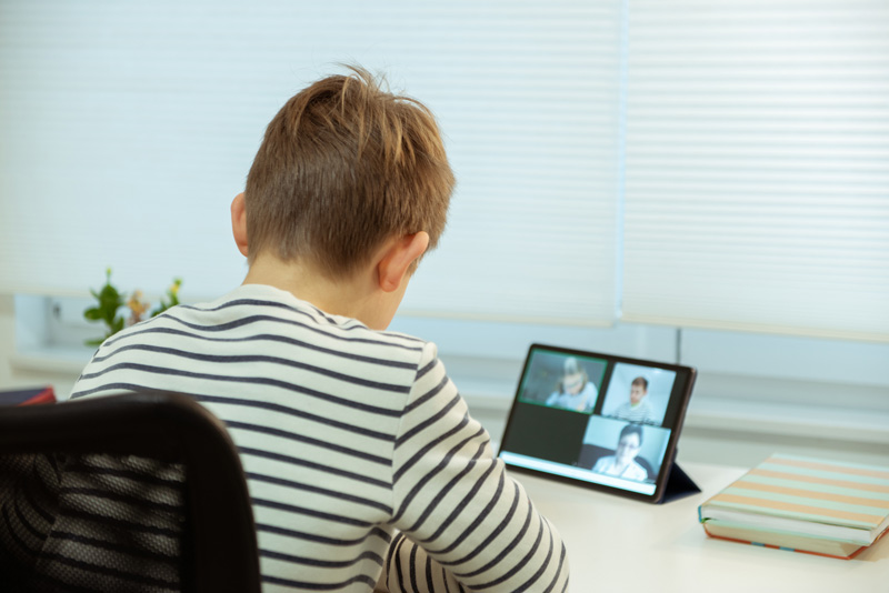 A young teen participates in online therapy on his tablet representing one of the benefits of online Therapy for Teens in Arlington, MA.