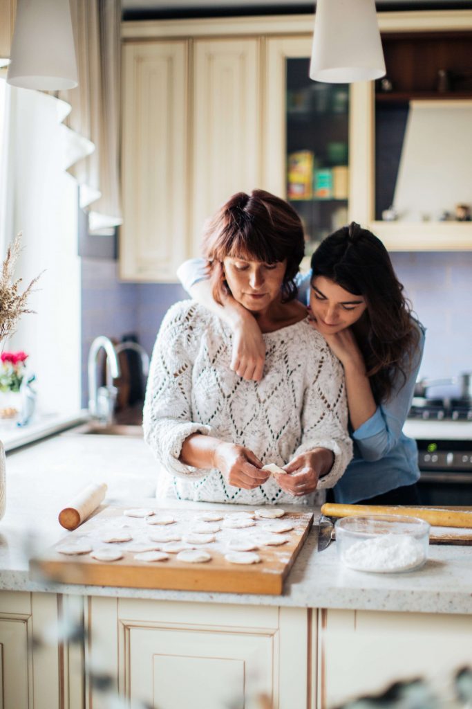 A mom and her teenage daughter make cookies in the kitchen while discussing life issues. Therapy for Teens in Arlington, MA is a great resource for parents and teens both. Reach out today.
