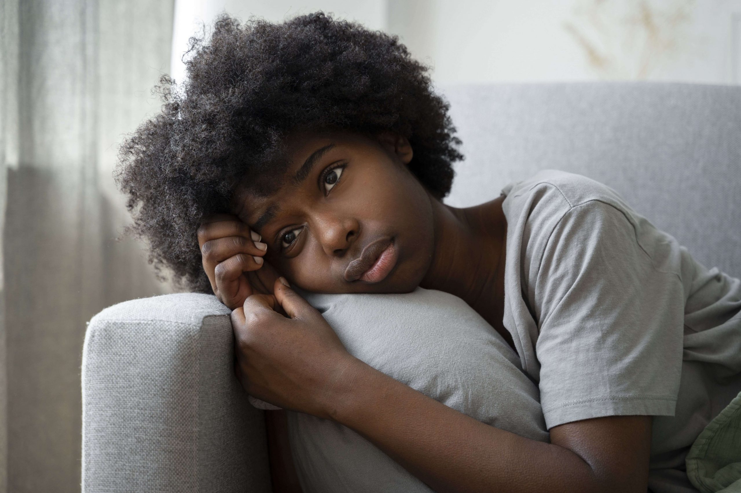 A teen girl lays down on couch thinking. Has your teen been struggling with depression? Therapy for Teens in Arlington, MA can help your teen today.