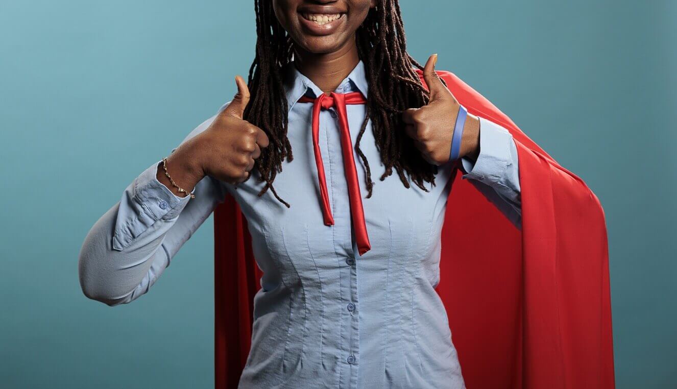 A smiling black girl with a cape smiles showing two thumbs up. Wonder how you can help teens with autism in Arlington, MA? Therapy for Teens can help teach teens through CBT. Speak with a teen therapist today.