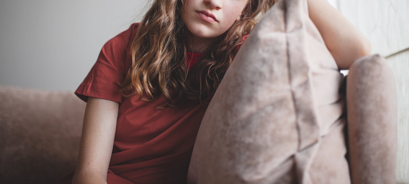 A teen girl sits on a couch while leaning on her arm. Wondering if therapy for teens in Arlington, MA can help your teens with autism in Arlington, MA? Speak with a teen therapist to see if it is right for your teen.