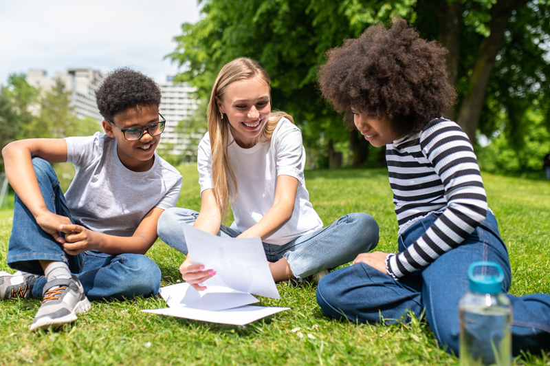 A group of teens sit in a school courtyard working on school work. Curious how Therapy for teens can help your teens with depression in Arlington, MA move forward? Speak with a teen therapist who can work with your teen.