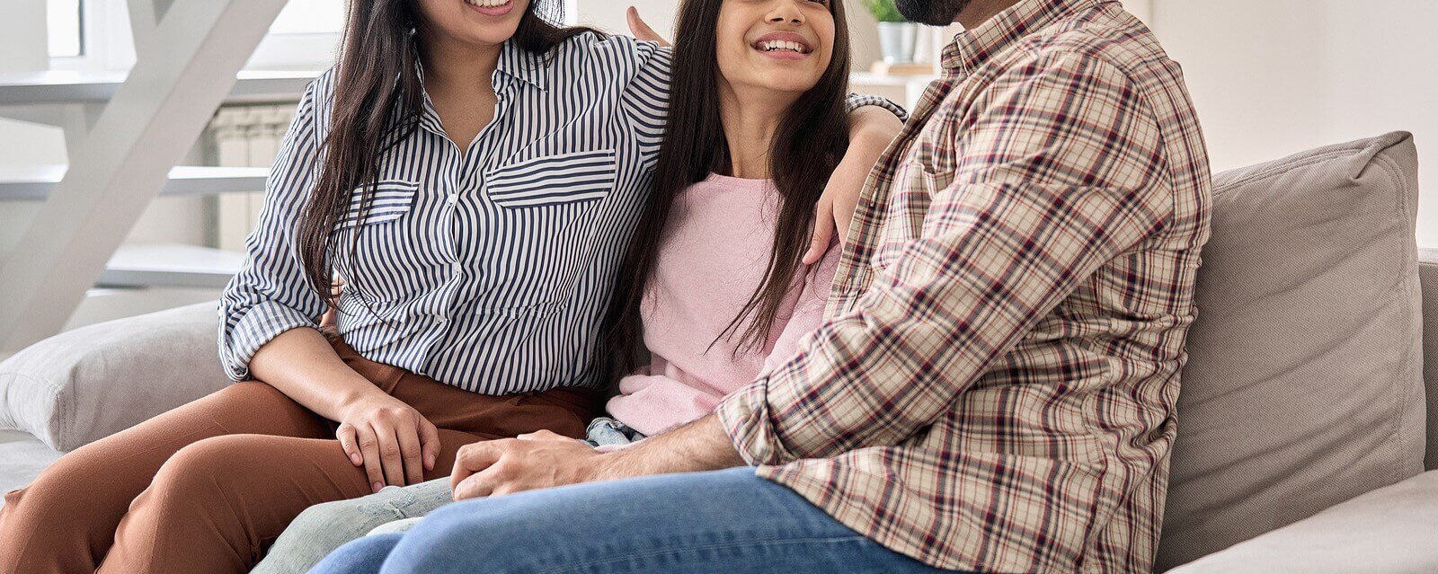 A family sits together on a couch. Looking for parental support as Anxious parents in Arlington, MA? Speak with a therapist to see if Therapy for Teens will provide you the support you need as a parent.