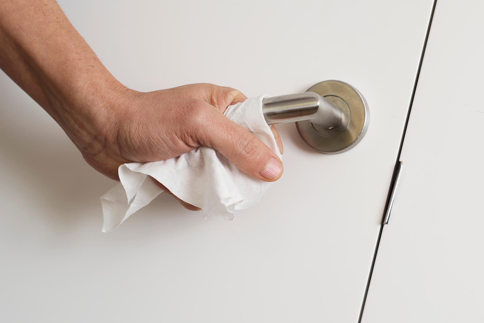 A person's hand touches the door handle with a cloth so their hand does not touch the handle. Noticing your teens with ocd in Arlington, MA having trouble managing their OCD? Speak with a teen therapist to get your teen the help they need!