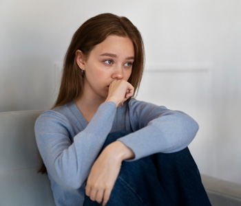 A teen sits alone looking anxious. This could represent the stress of anxiety that anxiety treatment in Arlington, MA can help you overcome. Learn more about teen anxiety and depression by searching for child counseling in Arlington, MA today.