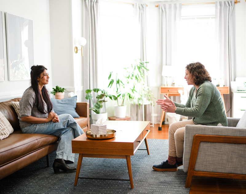 Mary Beth Medvide, therapist, sits opposite an adult during a therapy session at Bain Health & Wellness Center