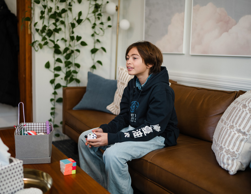 A preteen sits on the sofa during a therapy session at Bain Health & Wellness Center